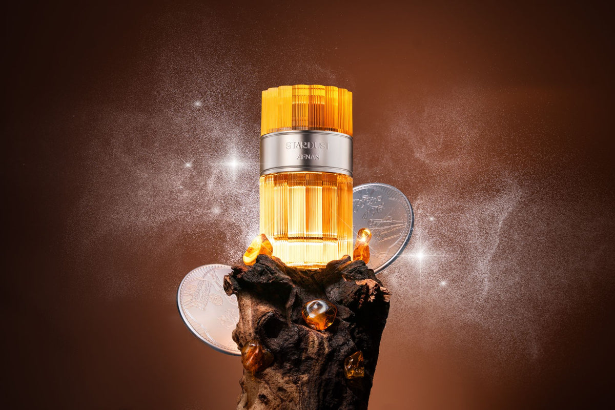 Afnan Stardust Extrait de Parfum, flacone ambra su legno con riflessi di luce