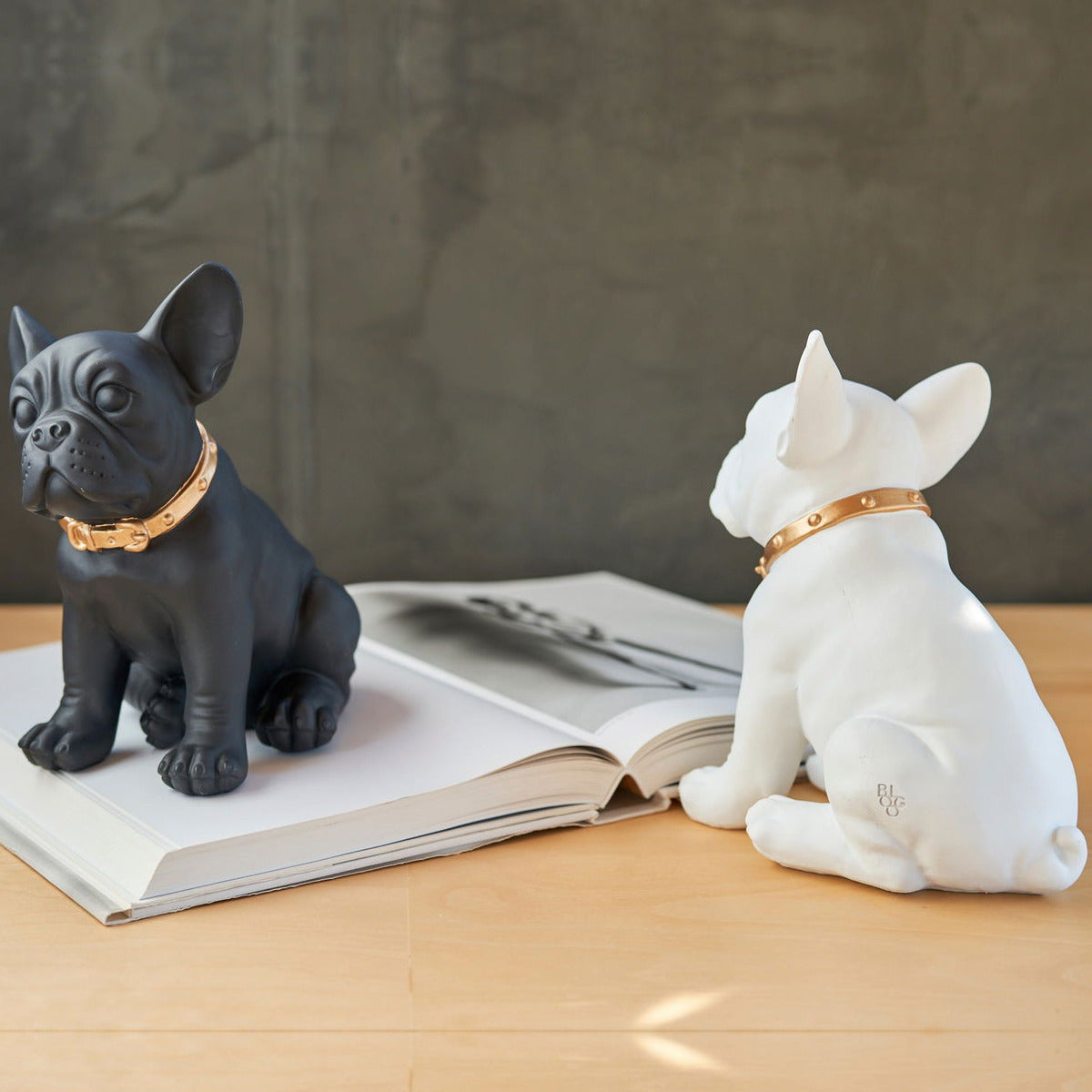 Statue bulldog francese Blogo Design Ruggiero nera e bianca su un tavolo, la bianca vista da dietro