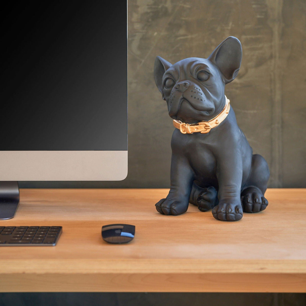 Statua bulldog francese Blogo Design Ruggiero nera su una scrivania accanto al computer