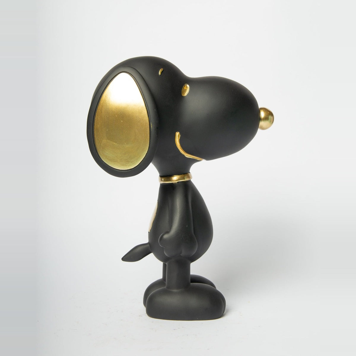 Statua Snoopy Standing Blogo Design nera e oro, di profilo dall'altro lato