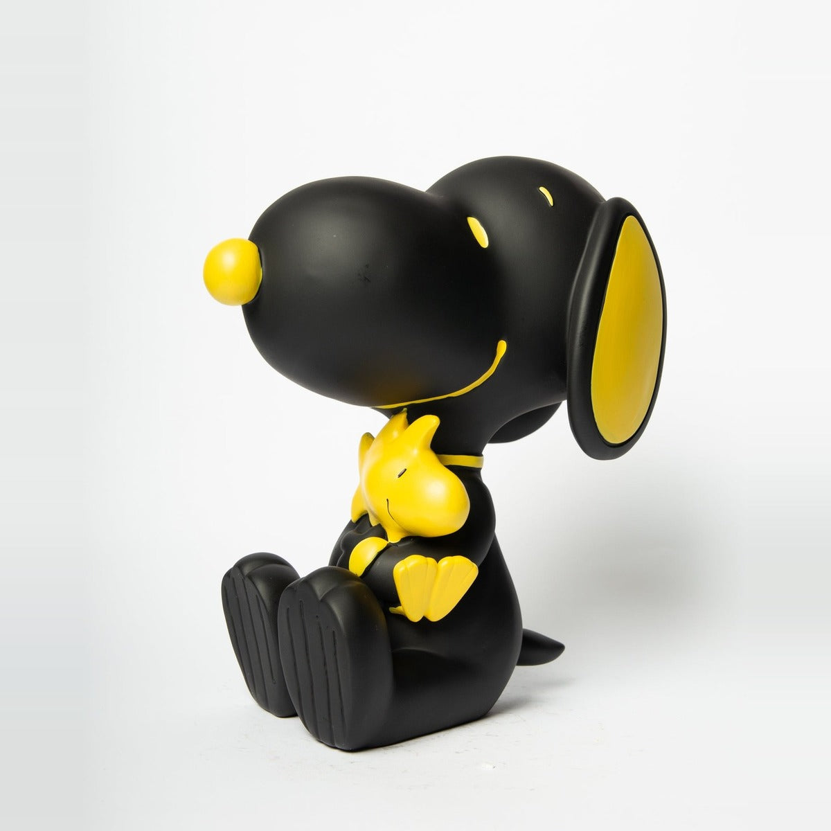 Statua Snoopy con Woodstock Blogo Design nera e gialla, vista di tre quarti