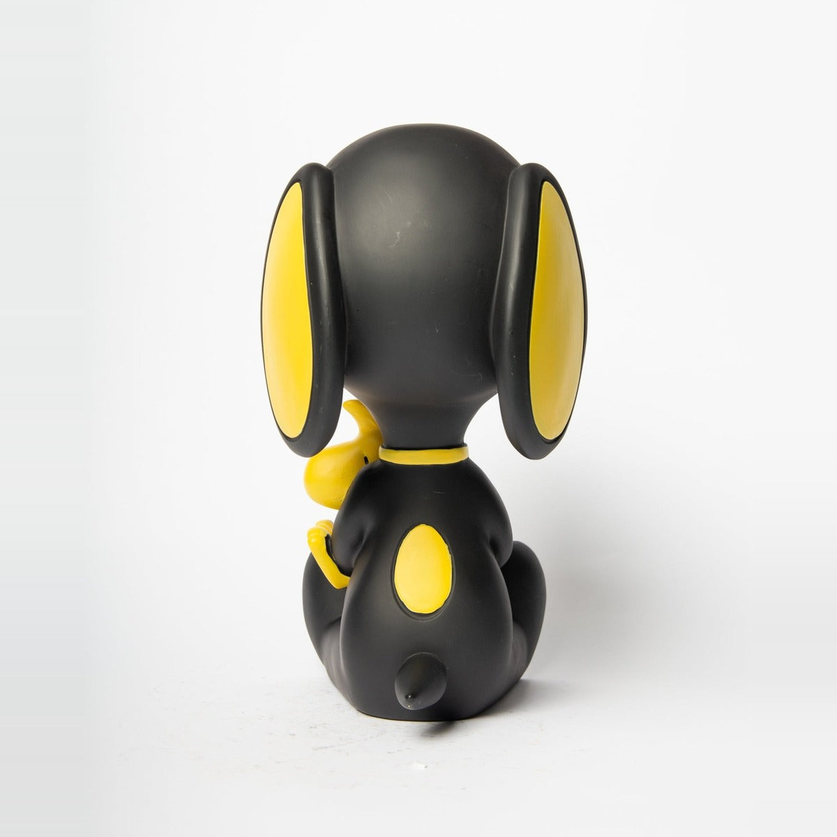 Statua Snoopy con Woodstock Blogo Design nera e gialla, di profilo dall'altro lato