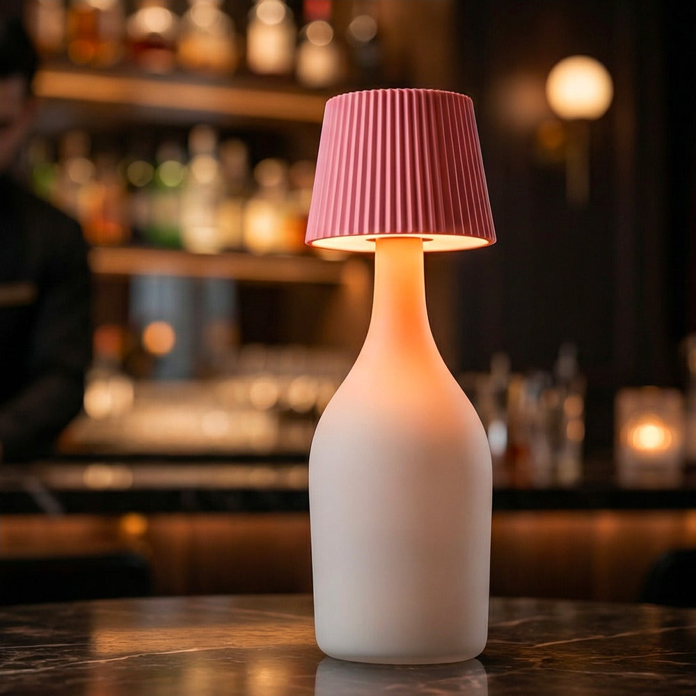 Lampada per bottiglia One-Light Sun flamingo, accesa su un tavolo