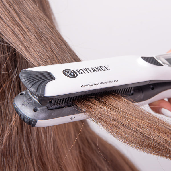 Piastra a vapore Stylance in uso su una ciocca di capelli